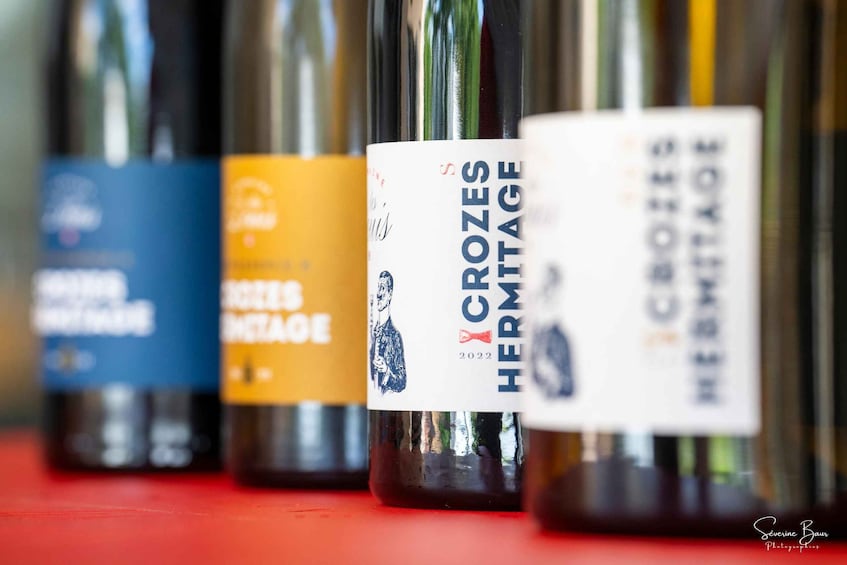 A row of wine bottles with labels. 5