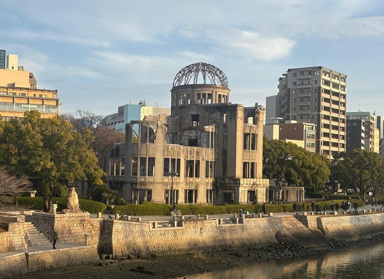 A historic building with a Ferris wheel, a river, and modern high-rise buildings in the background. 5
