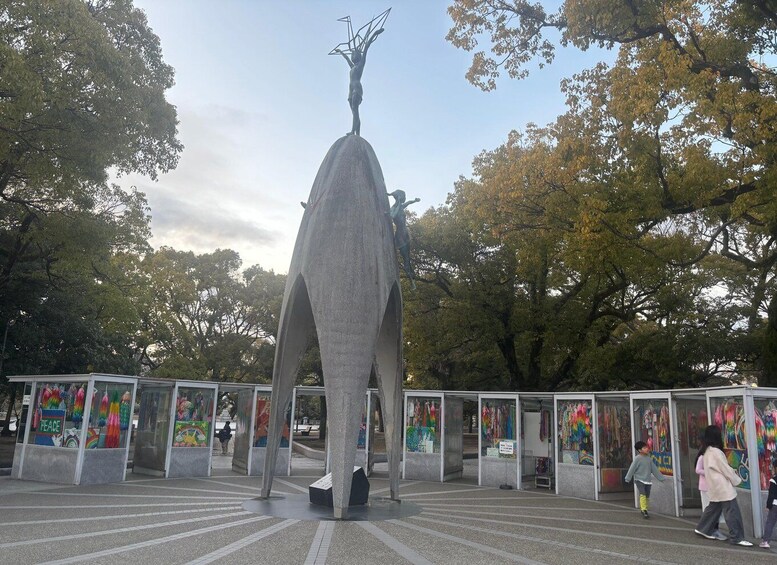 A large sculpture in a park with colorful murals on the surrounding walls. 3