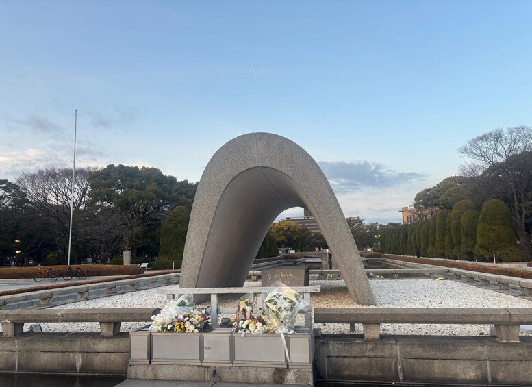 A large concrete arch structure with flowers and bicycles in the foreground. 2