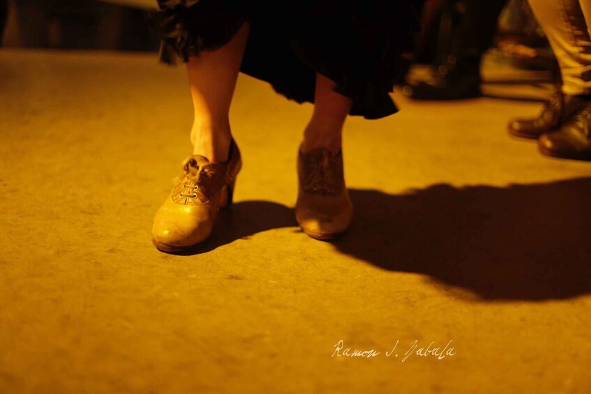A close-up of a person's feet wearing shoes, with a shadow cast on the ground. 5