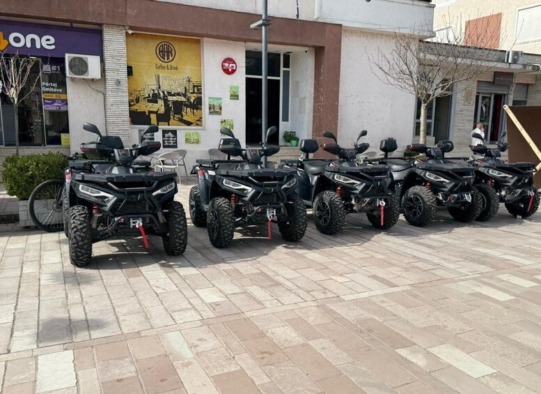 A row of ATVs parked in front of a building with a 'Coffee & Drink' sign. 3