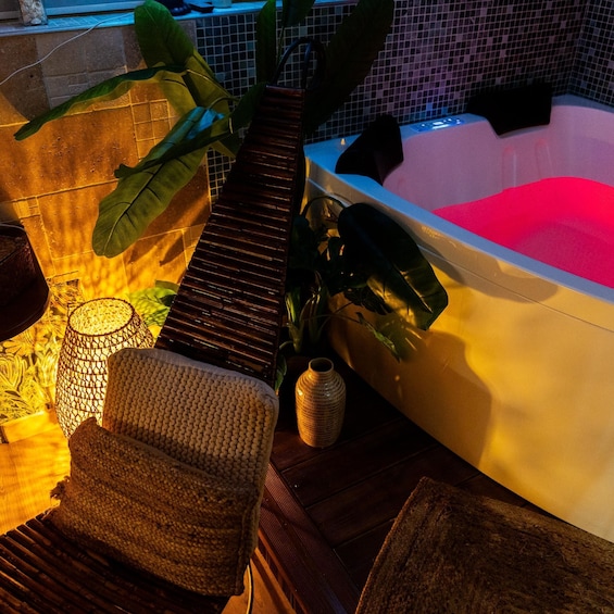 A hot tub, a woven chair, a potted plant, and a tiled floor. 3