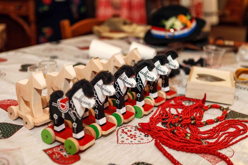 Wooden toy soldiers, red beaded necklaces, and a Christmas tree decoration on a table. 1