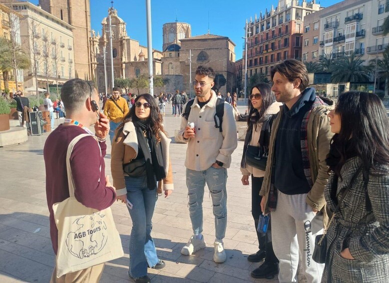 A group of people standing in a public square with historical buildings in the background. 5