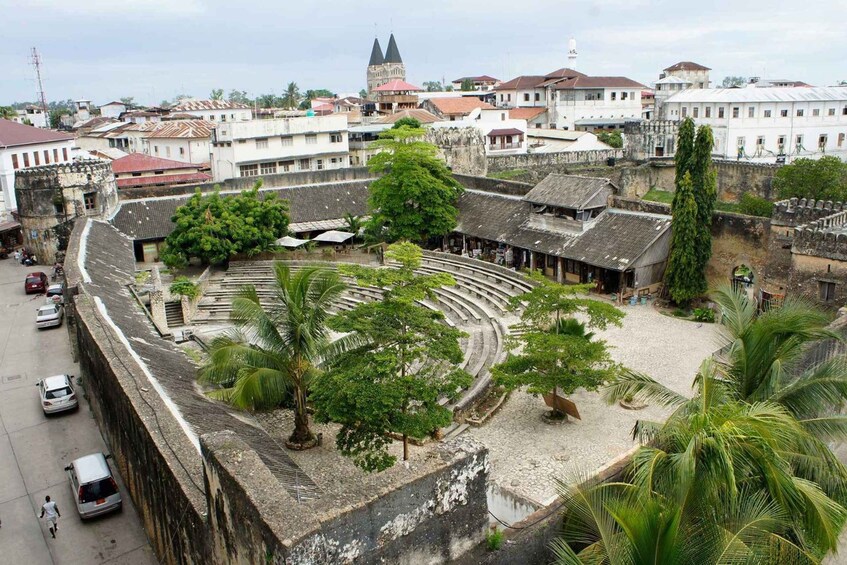 A historical amphitheater surrounded by buildings and palm trees. 2