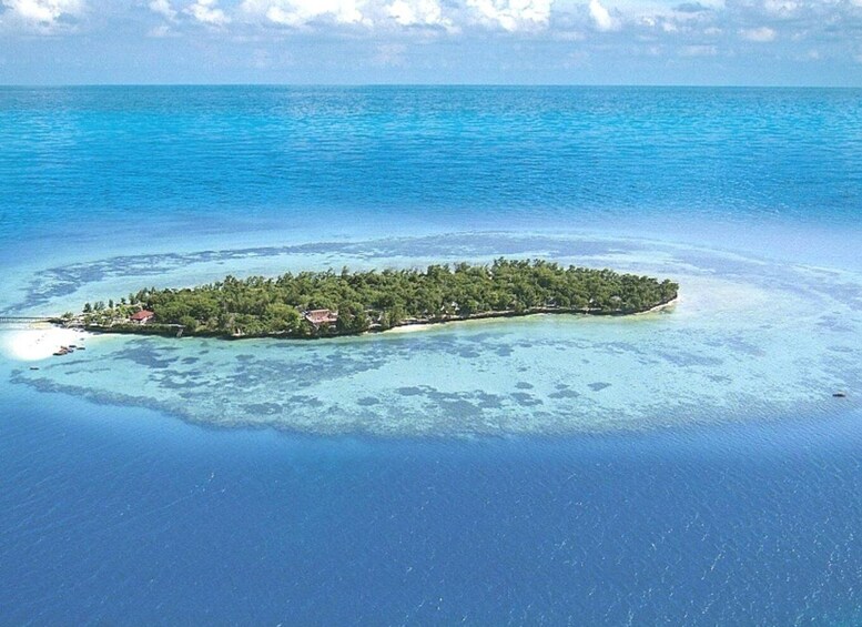 A small island surrounded by clear blue waters. 4