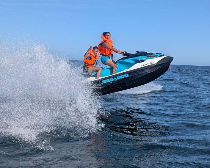 A jet ski with two people wearing life jackets, splashing water. 4