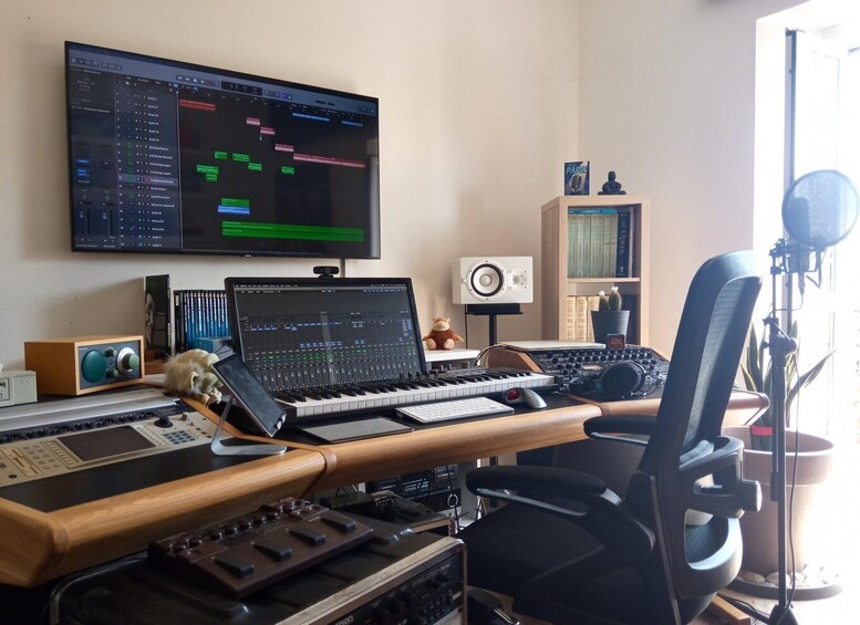 A home studio with audio equipment, a computer monitor displaying audio software, a keyboard, a mixing console, and a recording setup. 2