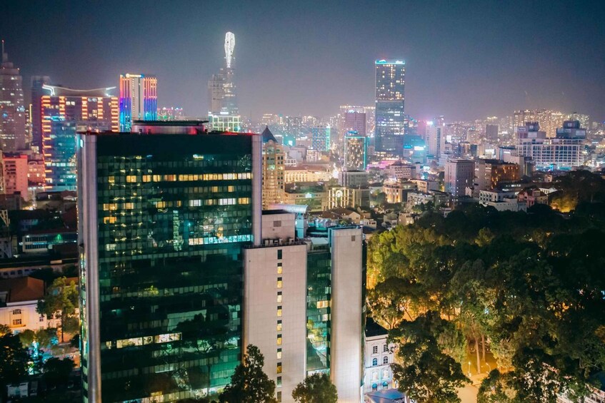 A cityscape at night with illuminated buildings and a prominent skyscraper in the background. 4