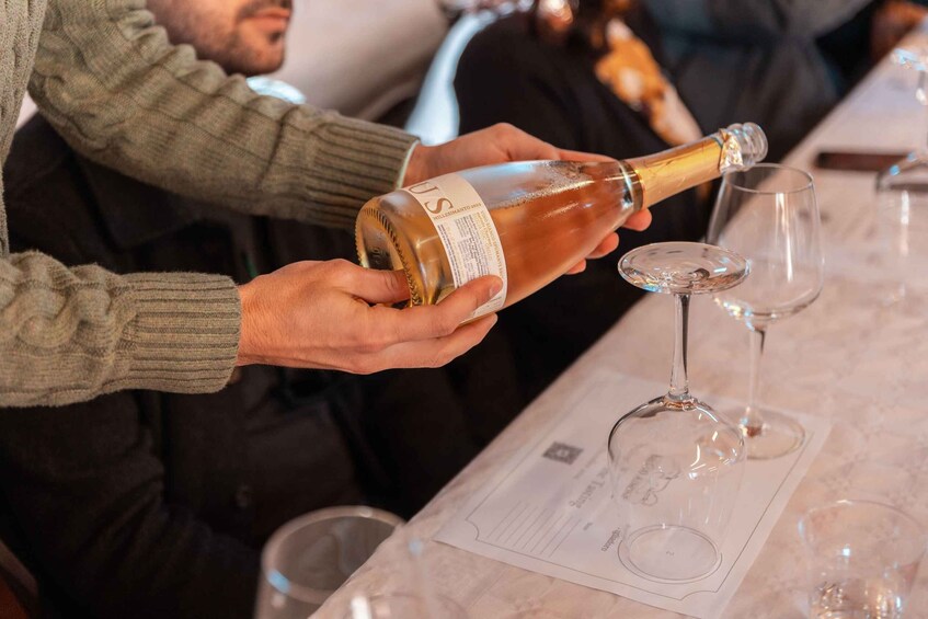A person pouring champagne into a glass. 4
