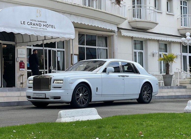 A white Rolls-Royce parked in front of the Le Grand Hotel. 1