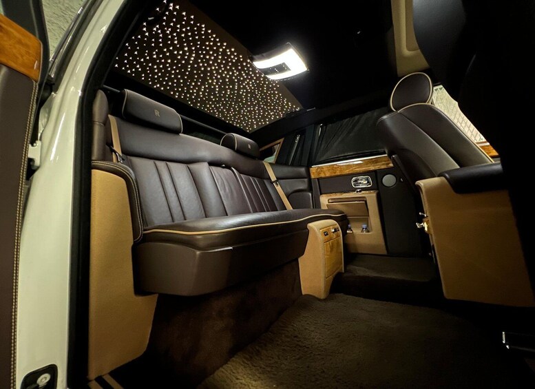 A luxurious van interior with leather seats, a central console, and a ceiling light. 2