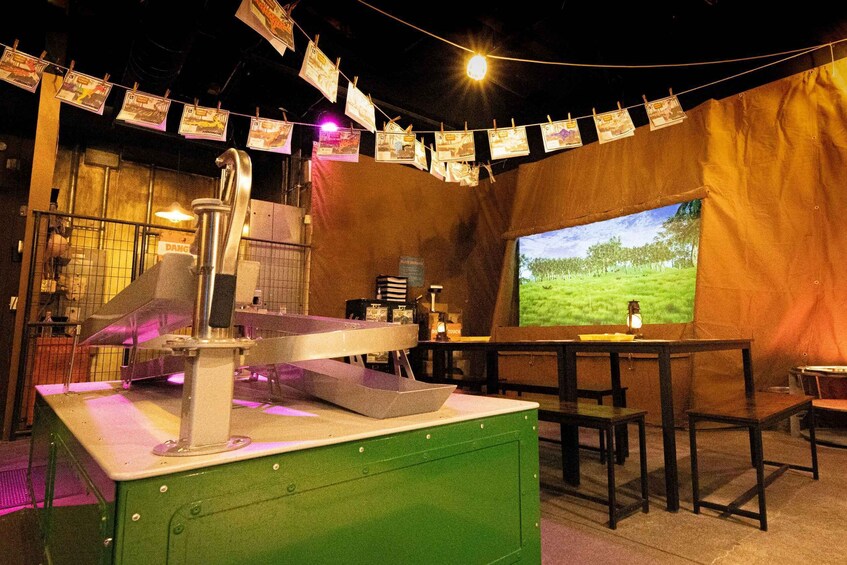 A vintage kitchen with a green counter, a metal sink, and a projector screen displaying a landscape. 5