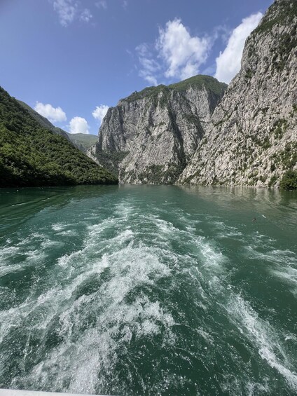 A river with white water rapids, surrounded by steep cliffs and lush greenery. 1
