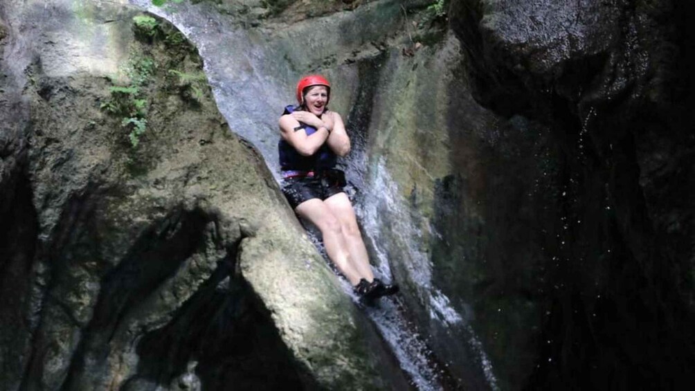 A person rappelling down a rocky cliff. 2