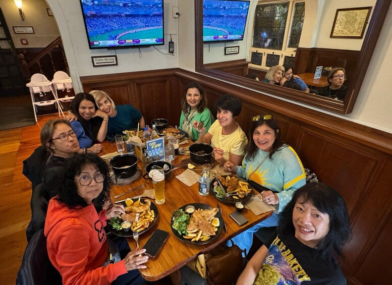 A group of people dining at a restaurant with multiple televisions displaying sports events. 2