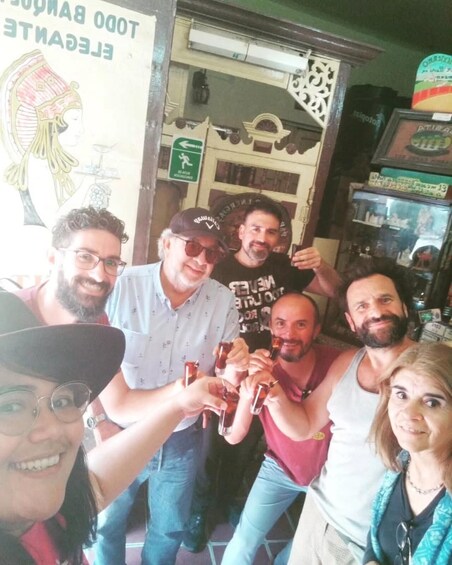 A group of people toasting with drinks in a bar with a sign that reads '1000 BAR'. 5