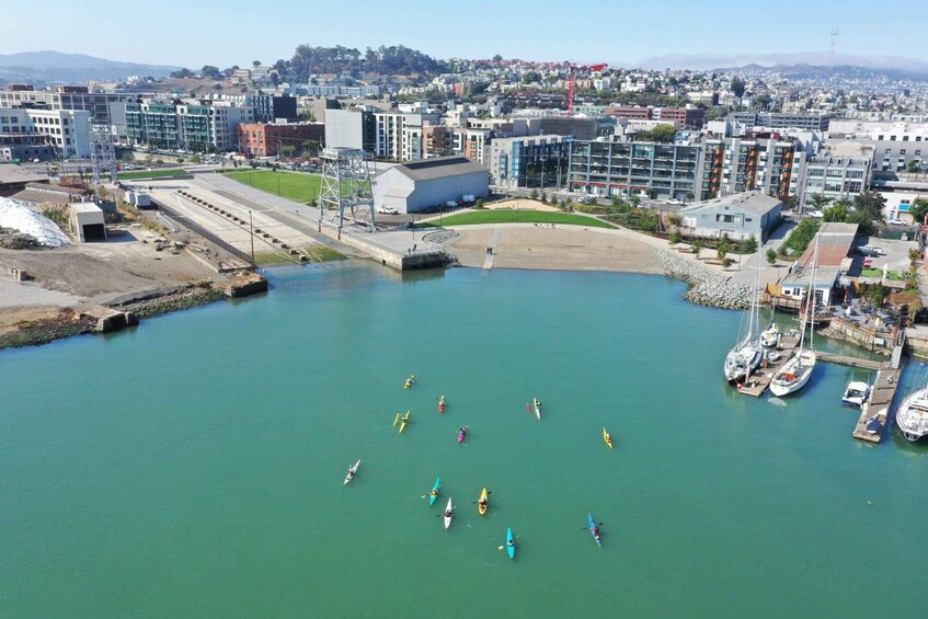 A marina with several boats, a large building, and a cityscape in the background. 3