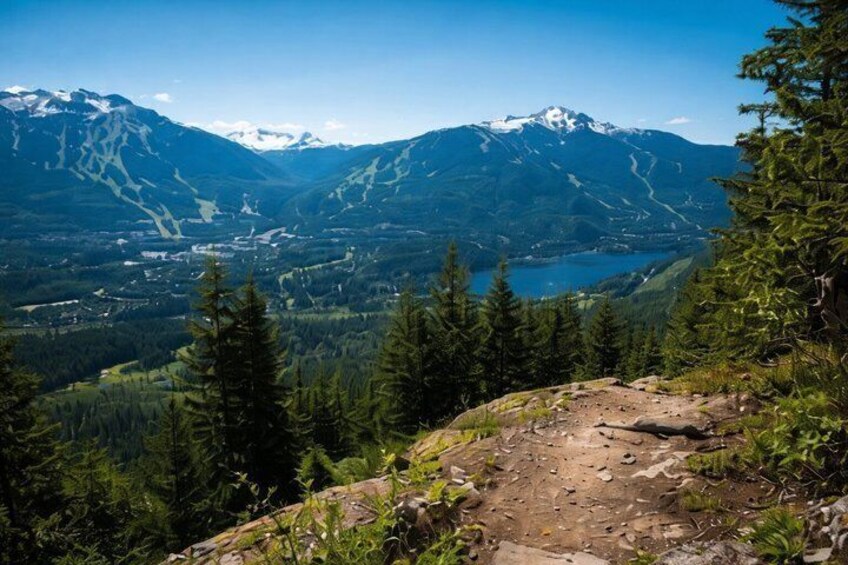 A mountain landscape with a lake, forest, and ski trails. 3