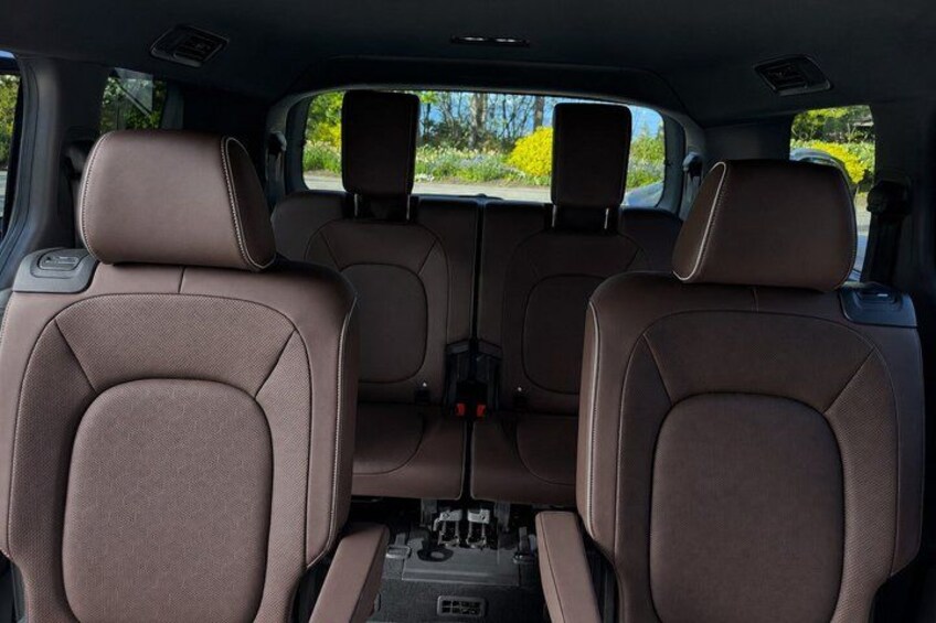The interior of a car with brown seats and a central console. 2