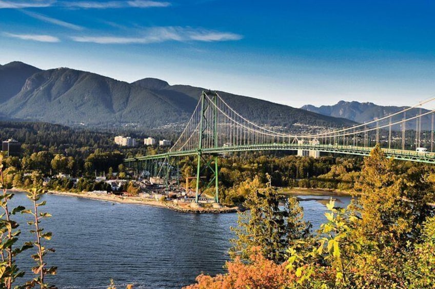A suspension bridge over a river with mountains in the background. 3