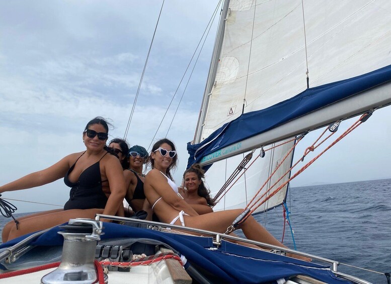 A sailboat with four people on board, sailing on the ocean. 4