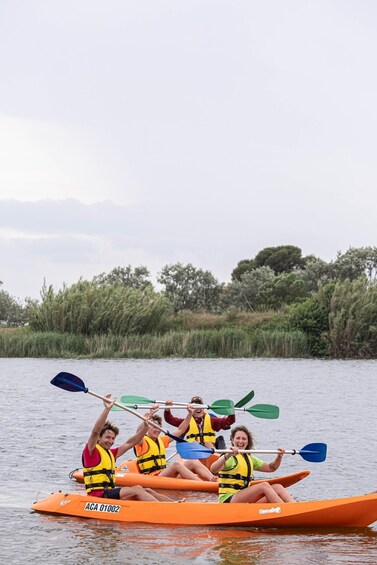 A group of people kayaking on a calm river surrounded by greenery. 3