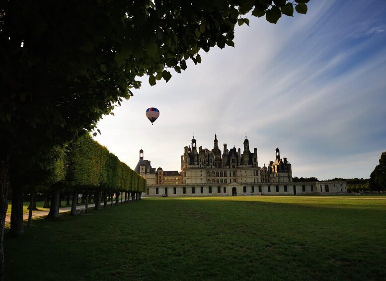 A historic building with a large lawn in front. 3