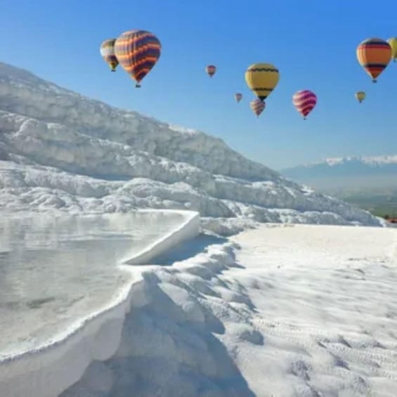 A snowy landscape with hot air balloons in the sky. 2