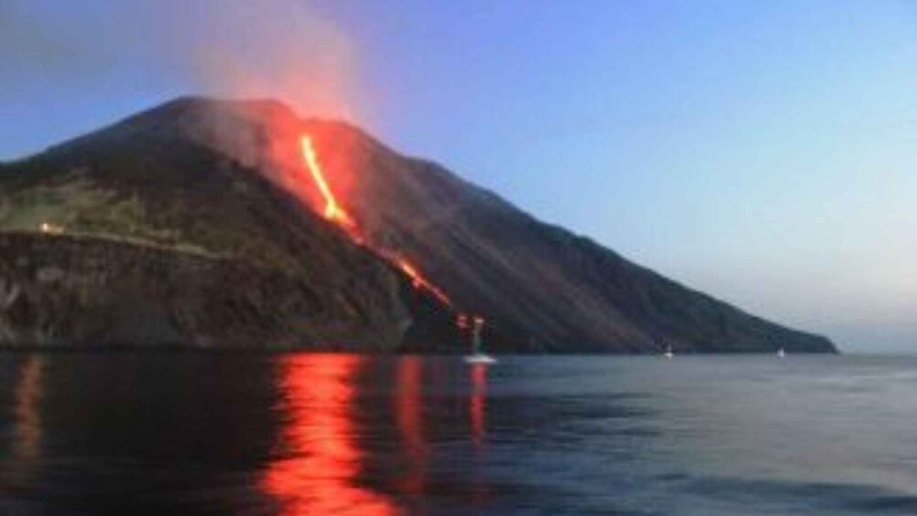 A volcano erupting with lava flowing into the sea. 1