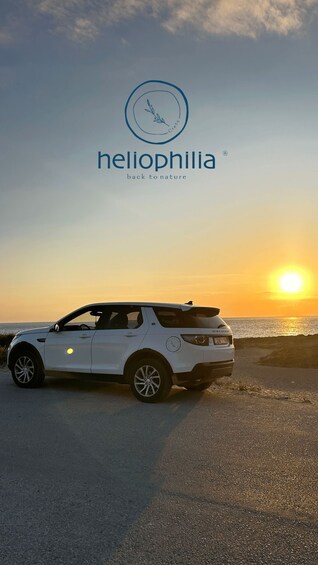A white car parked on a beach at sunset. 3