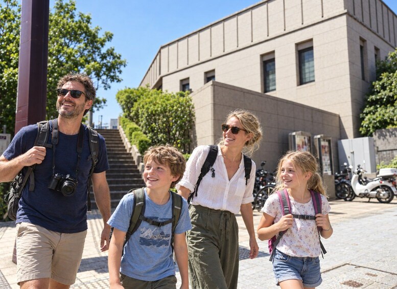 A family walking on a sidewalk with a building and trees in the background. 3
