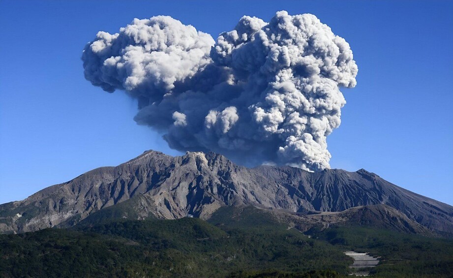 A mountain with a large plume of smoke or ash rising from its peak. 3