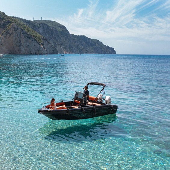 A clear blue sea with a boat carrying two people. 2