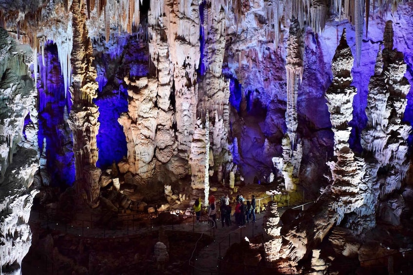 A cave with stalactites and stalagmites, illuminated by artificial lighting. 2