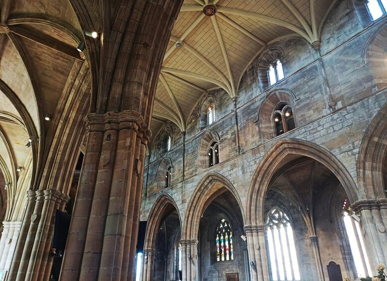 A cathedral interior with Gothic arches, large columns, and stained glass windows. 4