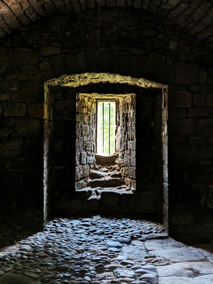 A stone staircase leading to a window in a stone building. 5