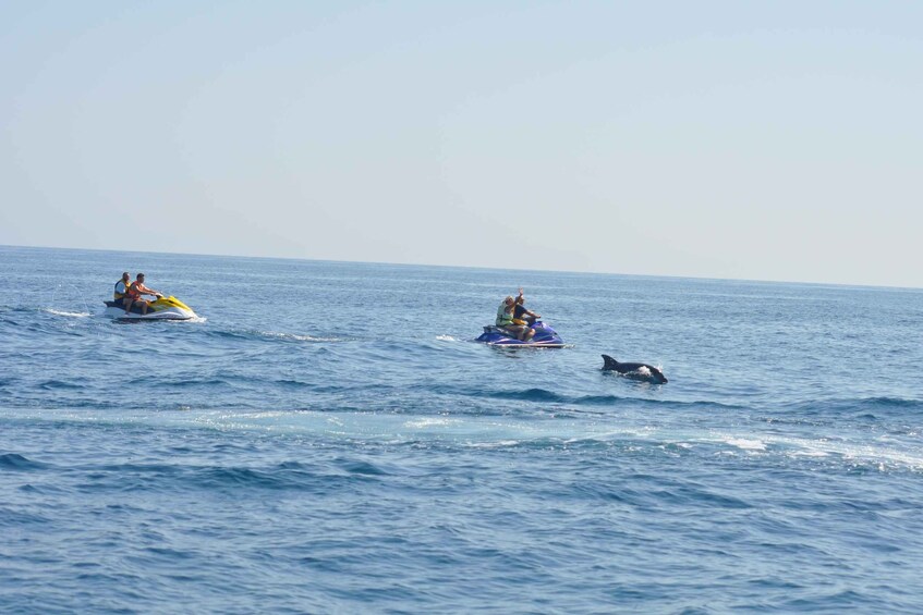 Three people on jet skis in the ocean. 1