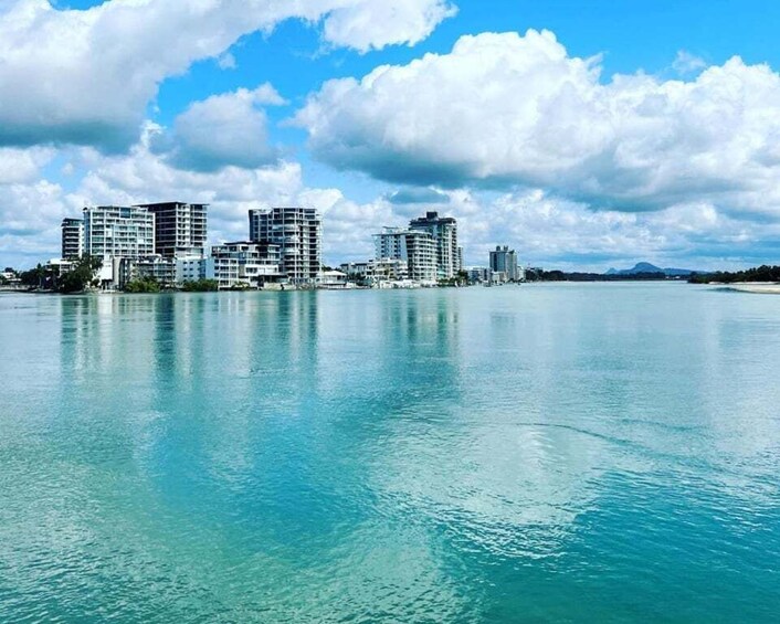 A coastal cityscape with buildings along the waterfront and a clear sky. 5
