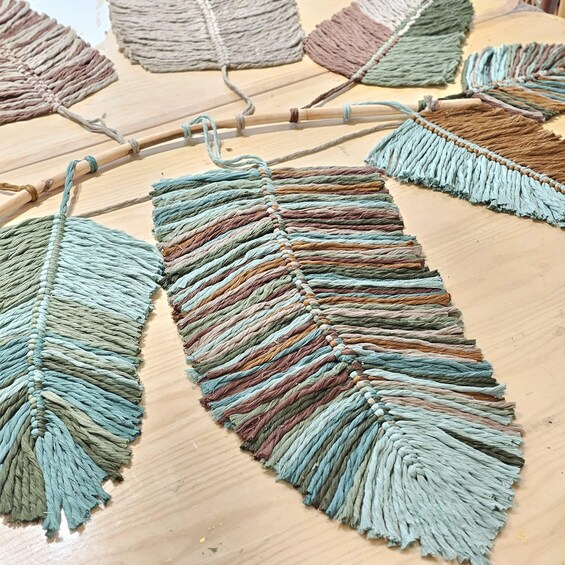 A close-up of a macramé wall hanging with multiple strands of yarn in various colors. 4