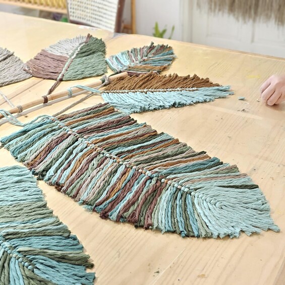 A wooden table with a large, colorful macramé piece. 5