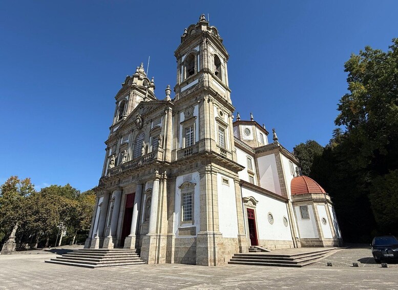 A historic church with a bell tower, a dome, and a red door. 1
