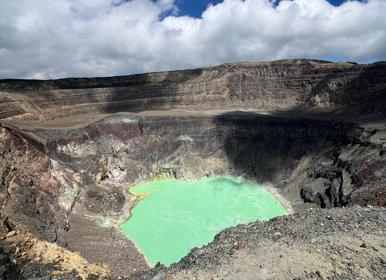 A large open-pit mine with a greenish pool of water at the bottom. 4