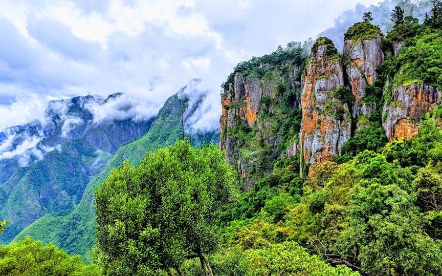A mountainous landscape with lush greenery and rocky cliffs. 2