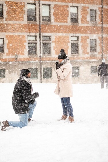 A snowy scene with a person kneeling and another standing, possibly in a proposal. 5
