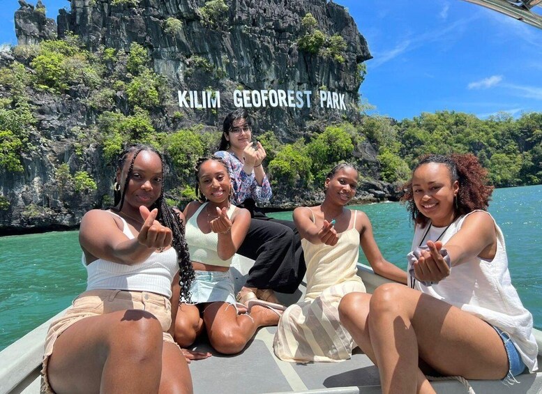 A group of people on a boat in front of Kilim Geoforest Park. 1