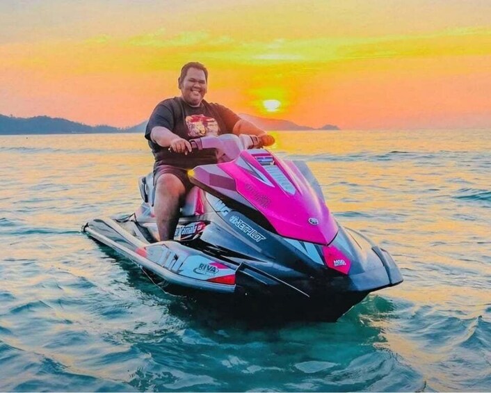 A person riding a jet ski on a body of water during sunset. 3
