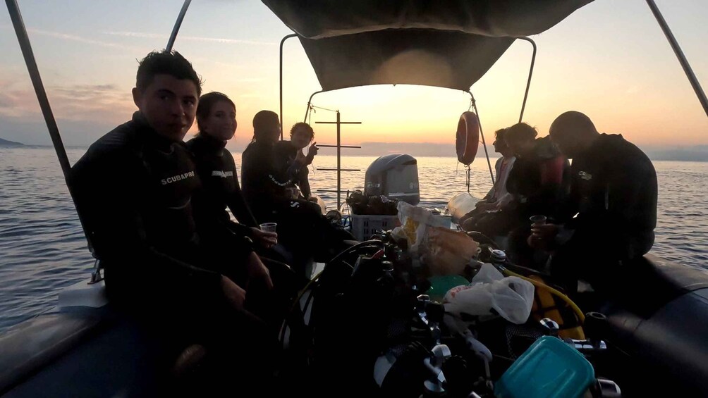 A group of people on a boat with a cross and various equipment visible. 3