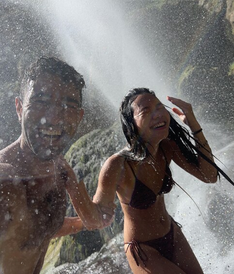 Two people in a water body with water splashing around them. 3